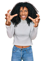 Young african american girl wearing casual clothes shouting frustrated with rage, hands trying to strangle, yelling mad