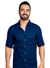 Canvas Print - Young hispanic man with beard wearing casual blue shirt looking positive and happy standing and smiling with a confident smile showing teeth