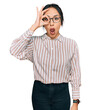 © Krakenimages.com - Young hispanic girl wearing casual clothes and glasses doing ok gesture shocked with surprised face, eye looking through fingers. unbelieving expression.
