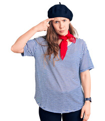 Poster - Young beautiful blonde woman wearing french beret and striped t-shirt pointing unhappy to pimple on forehead, ugly infection of blackhead. acne and skin problem