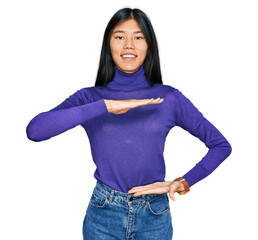 Sticker - Beautiful young asian woman wearing casual clothes gesturing with hands showing big and large size sign, measure symbol. smiling looking at the camera. measuring concept.