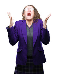 Sticker - Young brunette student girl wearing school uniform and glasses over isolated background celebrating mad and crazy for success with arms raised and closed eyes screaming excited. Winner concept