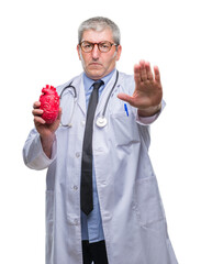 Wall Mural - Handsome senior cardiologist doctor man holding heart over isolated background with open hand doing stop sign with serious and confident expression, defense gesture