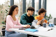 © Prostock-studio - Group of diverse students studying for test, making project or homework together, focus on asian lady using laptop