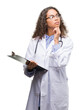 © Krakenimages.com - Young hispanic doctor woman holding a clipboard serious face thinking about question, very confused idea