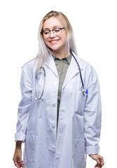 Poster - Young blonde doctor woman over isolated background looking away to side with smile on face, natural expression. Laughing confident.