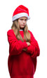 © Krakenimages.com - Young beautiful girl wearing christmas hat over isolated background skeptic and nervous, disapproving expression on face with crossed arms. Negative person.