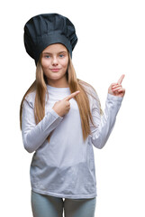 Wall Mural - Young beautiful girl wearing chef hat uniform over isolated background smiling and looking at the camera pointing with two hands and fingers to the side.