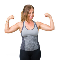 Sticker - Beautiful middle age woman wearing sport clothes over isolated background showing arms muscles smiling proud. Fitness concept.