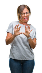 Poster - Middle age senior hispanic woman wearing glasses over isolated background disgusted expression, displeased and fearful doing disgust face because aversion reaction. With hands raised