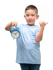 Canvas Print - Little child holding alarm clock pointing with hand and finger up with happy face smiling