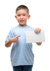 Canvas Print - Dark haired little child holding a blank card very happy pointing with hand and finger