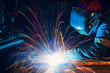 © Scopio - Person with welding shield using the machine