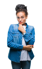 Poster - Young braided hair african american girl wearing glasses over isolated background looking confident at the camera with smile with crossed arms and hand raised on chin. Thinking positive.