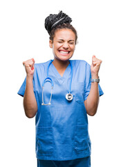 Sticker - Young braided hair african american girl professional surgeon over isolated background excited for success with arms raised celebrating victory smiling. Winner concept.