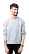 © Krakenimages.com - Young handsome man wearing sweatshirt over isolated background looking away to side with smile on face, natural expression. Laughing confident.