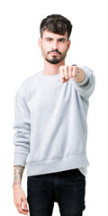 Sticker - Young handsome man wearing sweatshirt over isolated background Punching fist to fight, aggressive and angry attack, threat and violence