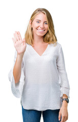 Wall Mural - Beautiful young elegant woman over isolated background Waiving saying hello happy and smiling, friendly welcome gesture