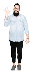 Sticker - Young hipster man with long hair and beard wearing glasses smiling positive doing ok sign with hand and fingers. Successful expression.