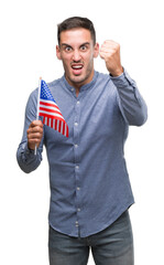 Sticker - Handsome young man holding a flag of America annoyed and frustrated shouting with anger, crazy and yelling with raised hand, anger concept