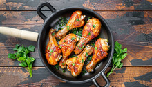 Baked Spicy Chicken Legs With Sesame And Parsley In Cast Iron Frying Pan On Dark Wooden Background Top View.