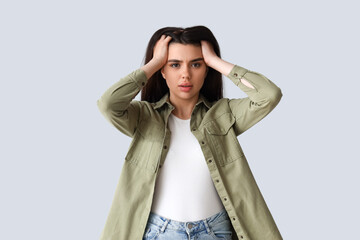 Wall Mural - Young woman having panic attack on light background