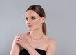 © New Africa - Beautiful woman with elegant necklace on light grey background