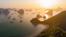 Panoramic Aerial View Of Sunset In The Hazy Horizon Of Halong Bay, Showing A Beach, Multiple Boats And Small Islands Scattered Across The Bay, Vietnam.