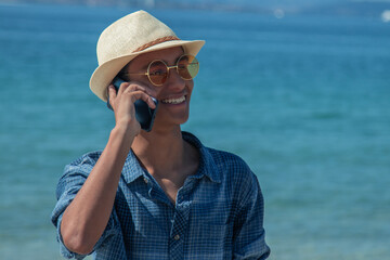 Wall Mural - young man on the beach talking on the mobile phone