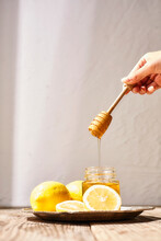 瓶詰めの蜂蜜とそのまわりに置かれたレモン