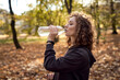 © gpointstudio - Side view of caucasian ginger woman drinking water