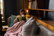 © Wavebreak Media - Biracial woman sitting on sofa, holding mug and reading book