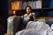 © Wavebreak Media - Biracial woman sitting on sofa, holding mug in living room
