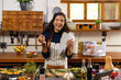 © Wavebreak Media - Portrait of happy biracial woman wearing apron cooking dinner in kitchen