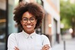 © Adriana - Young happy pretty smiling professional business woman, happy confident positive female entrepreneur standing outdoor on street arms crossed, looking at camera