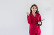 © David - Fun young woman of Asian ethnicity 20s years old wears red suit jacket hold in hand use tablet doing winner gesture clenching fists isolated on plain pastel light white background studio portrait