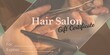 Composition of gift certificate text over hands of biracial female hairdresser giving cutting hair