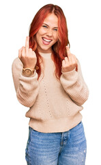 Sticker - Young redhead woman wearing casual winter sweater showing middle finger doing fuck you bad expression, provocation and rude attitude. screaming excited