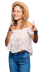 Wall Mural - Beautiful caucasian woman wearing summer hat pointing fingers to camera with happy and funny face. good energy and vibes.