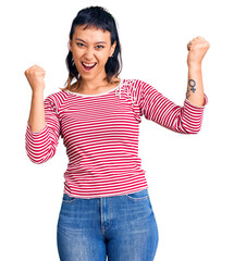 Wall Mural - Young woman wearing casual clothes screaming proud, celebrating victory and success very excited with raised arms