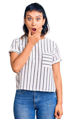 Sticker - Young woman wearing casual clothes looking fascinated with disbelief, surprise and amazed expression with hands on chin