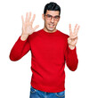 © Krakenimages.com - Handsome hispanic man wearing casual clothes and glasses showing and pointing up with fingers number eight while smiling confident and happy.
