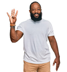 Poster - Young african american man wearing casual white tshirt showing and pointing up with fingers number four while smiling confident and happy.