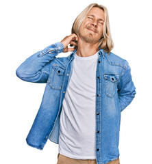 Poster - Caucasian man with blond long hair wearing casual denim jacket suffering of neck ache injury, touching neck with hand, muscular pain