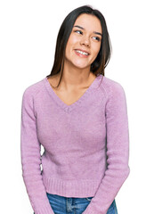 Poster - Young hispanic girl wearing casual clothes looking away to side with smile on face, natural expression. laughing confident.