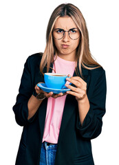 Sticker - Hispanic young woman drinking a cup of coffee skeptic and nervous, frowning upset because of problem. negative person.