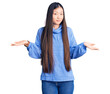 © Krakenimages.com - Young beautiful chinese woman wearing casual turtleneck sweater clueless and confused expression with arms and hands raised. doubt concept.