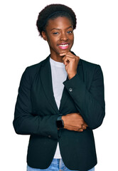 Wall Mural - Young african american girl wearing business clothes looking confident at the camera smiling with crossed arms and hand raised on chin. thinking positive.