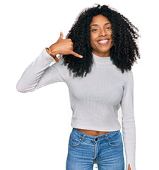 Wall Mural - Young african american girl wearing casual clothes smiling doing phone gesture with hand and fingers like talking on the telephone. communicating concepts.