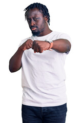 Poster - Young african american man with braids wearing casual white tshirt punching fist to fight, aggressive and angry attack, threat and violence